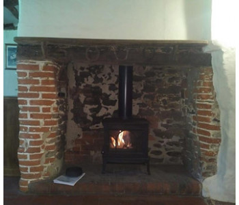 Jotul F100 Woodburning Stove - in the inglenook fireplace of a picturesque cottage set in the Surrey Hills near Cranleigh